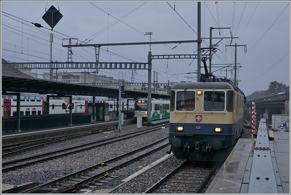 After the IRSI  Rheingold  Re 4/4 II 11387 (Re 421 387) arrived in Morges with its gravel train and pushed the train over the rolling trestle pit for the further journey on narrow-gauge tracks, the locomotive stopped for a long time. Unfortunately, the locations were hardly suitable for photography.

Feb 22, 2024