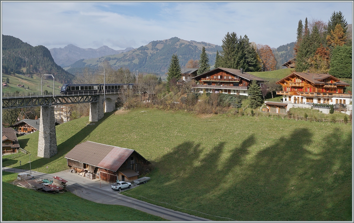 Against the backdrop of pretty chalais near Gstaad, he GoldenPass Express GEX reaches the Grubenbach Bridge.
The train is on its way from Interlaken Ost to Montbovon.

Nov 6, 2024