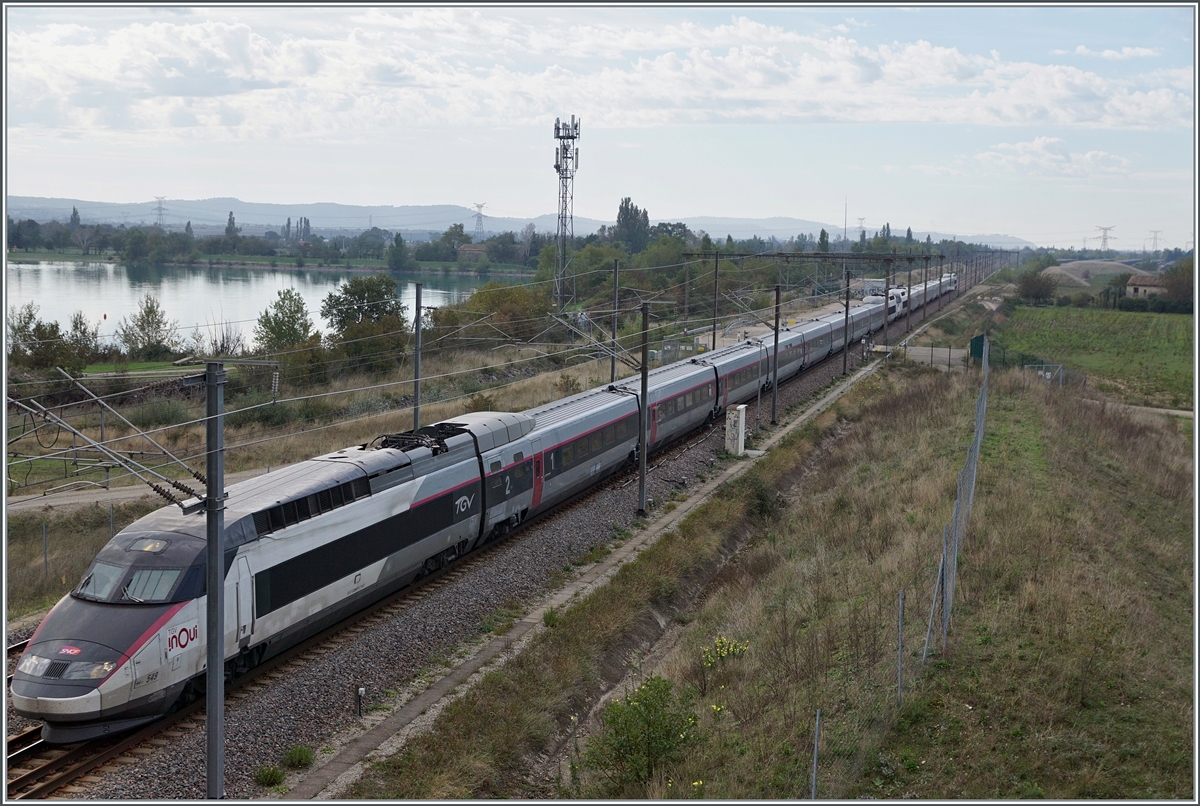 North of Bollène a road leads over the Rhone and then over two bridges to Lapalud. On the one hand, the two bridges lead over the LGV 75200 LN5 and barely twenty meters later over the route 830000 Paris - Marseille. The picture shows the SNCF INOIU TGV 2242 from Toulon to Colmar with the Rame 549 in the lead on the high-speed route 752 000 LGV Méditerranée LN5 at km 577.4 heading north. 

October 1, 2024