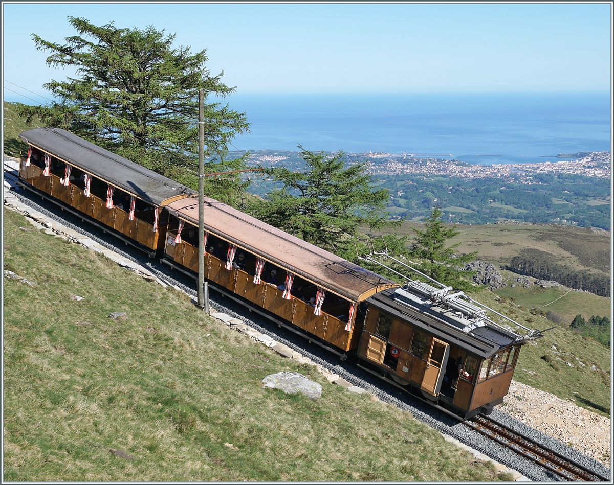 The route of the Chemin de Fer de La Rhune leads steeply uphill, and a He 2/2 three-phase locomotive is currently traveling along it with its train. 

April 12, 2024