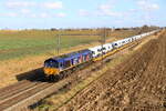 Locomotive 653 04 from HSL hauling a train of light road vehicles is passing in Pousset, 23/2/2025.