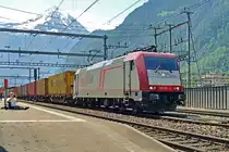 XR 185 601 hauls a container train through Erstfeld on 6 June 2015. The filmer in the background seems to be to lazy to stand on his feet while practising his hobby! 